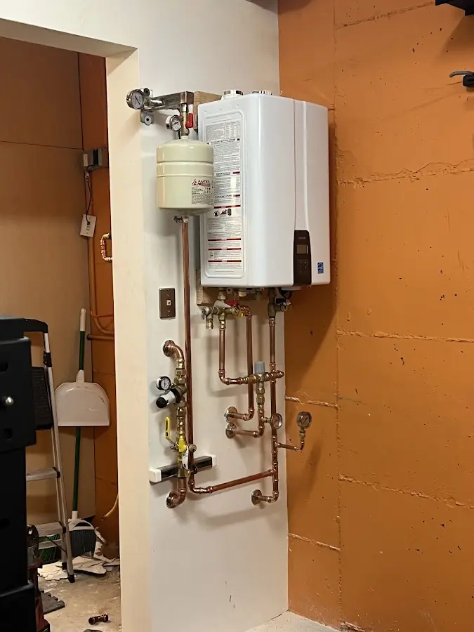 Plumbing technician inspecting water heater connections in Bonney Lake